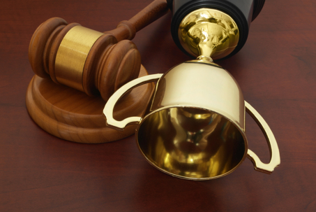 Golden trophy cup and gavel on wooden background