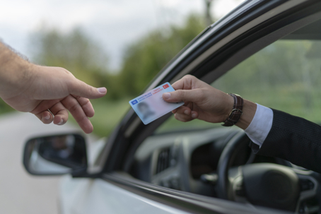 Traffic stop with driver showing license to officer.